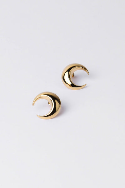 A pair of gold crescent moon hoop earrings on a clean, light gray background.