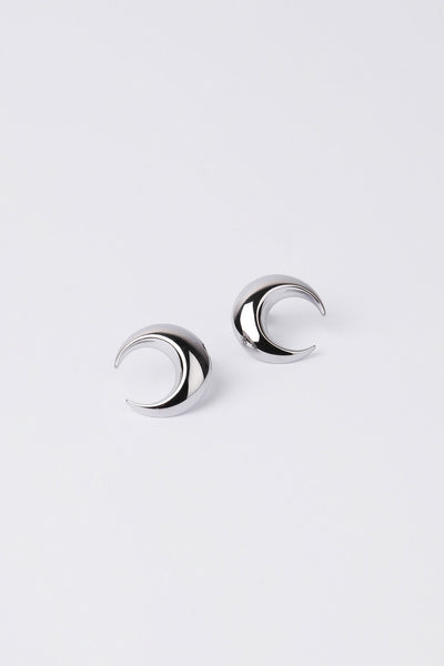 Pair of silver moon stud earrings on a light grey background.