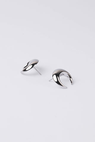 A pair of polished silver crescent moon stud earrings on a clean, light gray background.