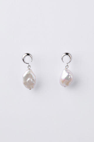 A pair of silver moon shape earrings with irregular white baroque pearls hanging below, displayed on a clean light gray background.
