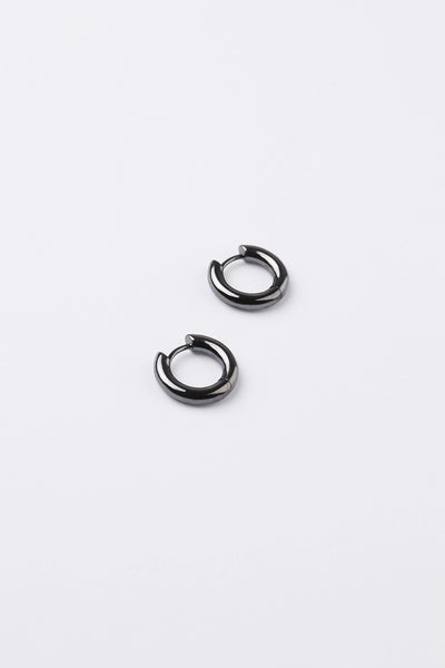 A pair of small black metal huggie hoop earrings on a clean white background.