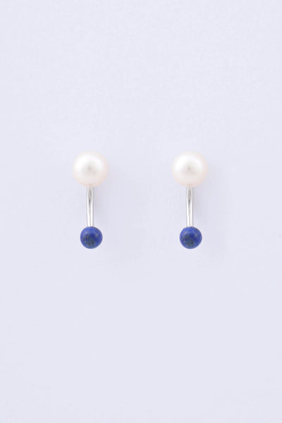 Pair of rhodium plated sterling silver earrings by Miro Miro, featuring a freshwater pearl and a spherical natural lapis lazuli stone hanging from a curved ear jacket.