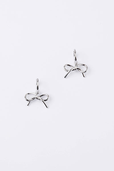 A pair of silver bow-shaped dangle earrings on a clean, light gray background.