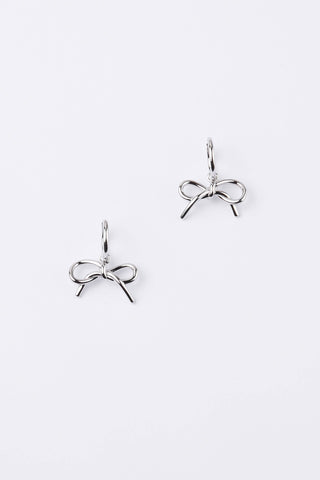 A pair of silver bow-shaped dangle earrings on a clean, light gray background.
