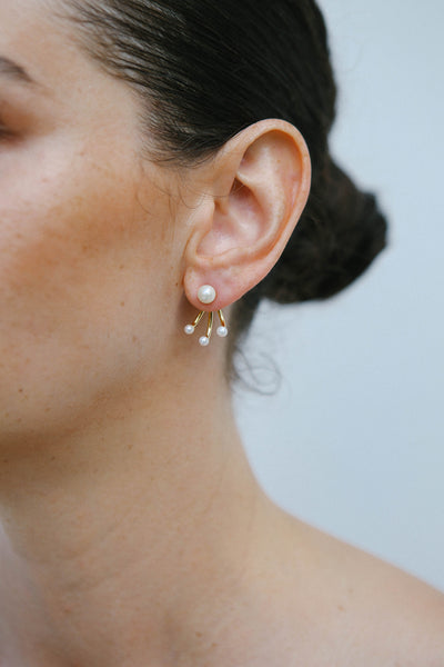 Model wears a freshwater pearl stud earring by Miro Miro.