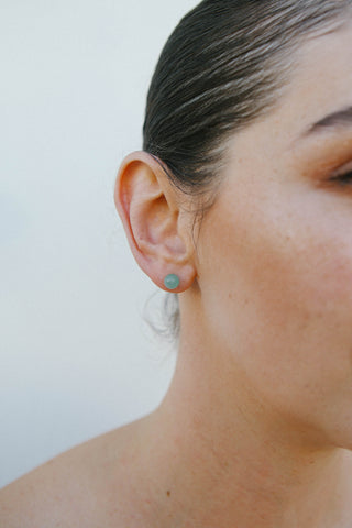 Model wears a spherical natural chrysoprase stud earring by Miro Miro.
