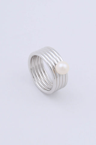 A rhodium plated sterling silver ring by Miro Miro, featuring a freshwater pearl set on a thick band with a ribbed textural finish.