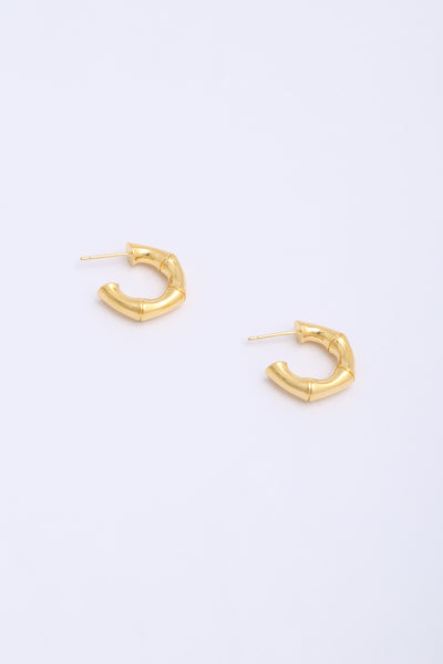 Thick, chunky gold hoop earrings in the shape of bamboo segments.