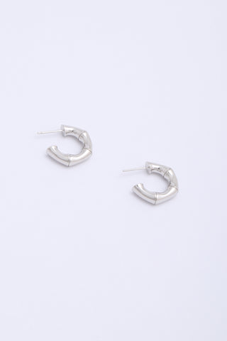 Thick, chunky silver hoop earrings in the shape of bamboo segments.