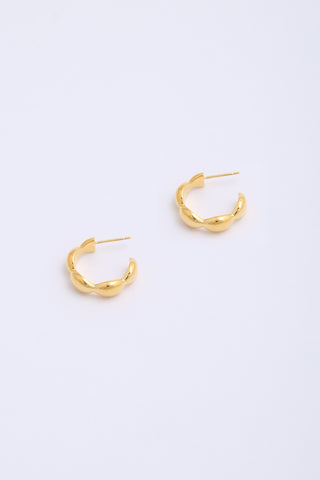 Chunky, bulbous gold hoop earrings.