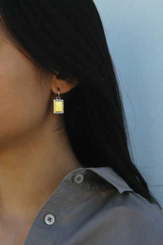 A rectangular shape drop earring made in a two tone silver and gold finish.
