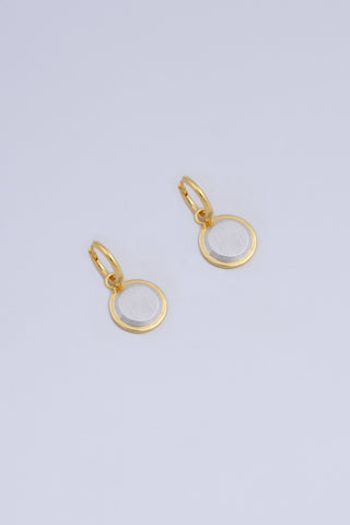 A pair of earrings featuring a circular drop shape, made in a two tone silver and gold finish.