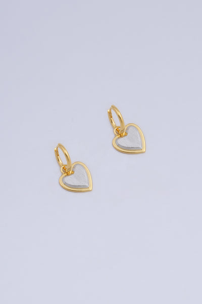 Pair of heart shape drop earrings in a two tone gold and silver finish.