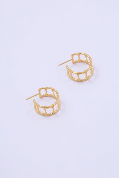 A pair of gold hoop earrings in the shape of cage-like bamboo segments.
