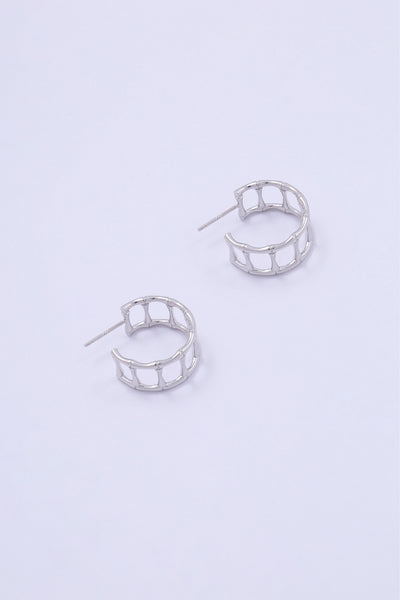 A pair of silver hoop earrings in the shape of cage-like bamboo segments.